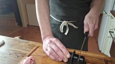 Bir aşçı hazırlanmadan önce bıçağı biler. Erkeklerin elleri et kesmeden önce mutfak bıçağını keskinleştirir. Gastronomi, aşçılık, ev yemeği kavramı..
