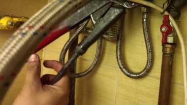 Tesisatçı gaz kazanının vanasını söker. Bir tamirci bir evde gaz kazanını tamir eder..