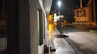 Şehirde yağmur yağıyor. Yağmurlu havada bir gece sokağı manzarası.