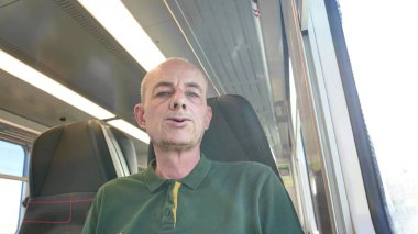 Bir adam trenle seyahat eder. Yaşlı bir adam trende. Günlük rutin ve işe gidip gelme kavramı.