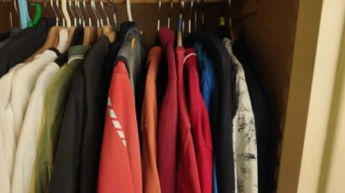 Erkek kıyafetleriyle dolu, dahili bir dolaba bakmak. Erkek kıyafetleri renklerine göre sıralanmış. Otizm ve Obsesif-kompulsif bozukluk kavramı - OKB.