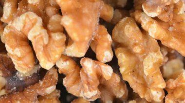 Bir yığın kabuklu ceviz. Dönen bir zeminde soyulmuş ceviz. Sağlıklı beslenme, doymamış yağ asitleri, B vitamini ve demir konsepti..