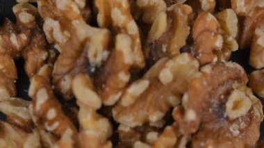 Bir yığın kabuklu ceviz. Dönen bir zeminde soyulmuş ceviz. Sağlıklı beslenme, doymamış yağ asitleri, B vitamini ve demir konsepti..