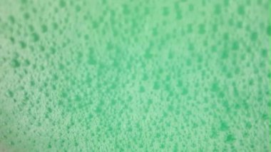 Baloncuklu sallanan bir turkuaz yeşil yüzey. Banyo köpüğüyle sallanan su yüzeyi. Sağlık, kaplıca ve kendine bakım kavramı.