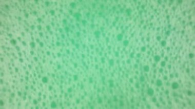 Baloncuklu sallanan bir turkuaz yeşil yüzey. Banyo köpüğüyle sallanan su yüzeyi. Sağlık, kaplıca ve kendine bakım kavramı.