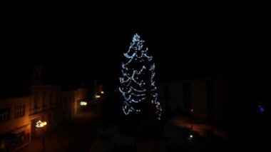 Aydınlatılmış Noel ağacı. Dışarıda ışıklandırılmış bir Noel ağacı yetiştiriyorum. Noel ağacının bulanık görüntüsü.