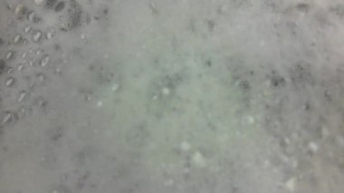 Dönen banyo köpüğü. Yavaş çekimde dönen banyo köpükleri. Bir kısmı bulanık. Refah, özgüven, refah kavramı.