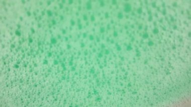 Baloncuklu sallanan bir turkuaz yeşil yüzey. Banyo köpüğüyle sallanan su yüzeyi. Sağlık, kaplıca ve kendine bakım kavramı.