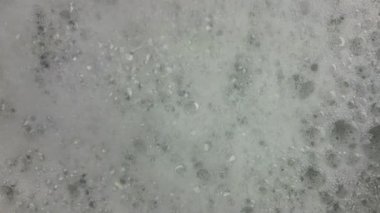 Dönen beyaz köpük. Dalgalı banyo köpüğü. Sağlık ve kaplıca konsepti.