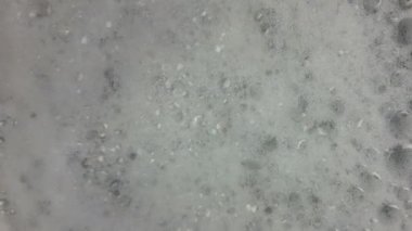 Dönen beyaz köpük. Dalgalı banyo köpüğü. Sağlık ve kaplıca konsepti. Yakın plan..