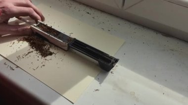 Sigara tüplerini tütünle dolduruyorum. Sigara tüpleri ve tütün. Kendi sigaranı yapma fikri. Düşük sigara ve tütün tüketimi kavramı.