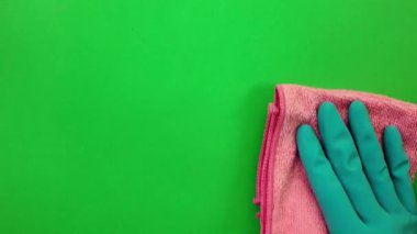 Bardağı pembe bir mendille siliyorum. Lastik eldiven, krom anahtarın arkasındaki camları siliyor. Ev işleri ve temizlik kavramı.