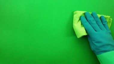 Yeşil bir bezle yüzeyi siliyorum. Cam pencereyi mendille ovmak. Yeşil ekran krom anahtar arka planında yeşil bir bez ile yüzeyi siliyorum. Pencereleri temizleme dezenfektanı ile temizliyorum