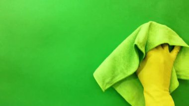 Sarı lastik eldivenli bir el, cam camını kuru bir bezle siler. Yakın plan. Yeşil ekran, krom anahtar.