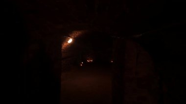 Eski mahzenlerden geçiyorum. Mumlarla aydınlatılmış eski bir yeraltı koridorunda yürü. Gizem ve korku kavramı.