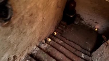 Mumlarla aydınlatılmış eski merdivenler. Eski mahzenlerden geçiyorum. Mumlarla aydınlatılmış eski yeraltı koridorunda yürü. Gizem ve korku kavramı.