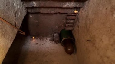 Merdivenlerden yeraltı koridorlarına iniyor. Mumlarla aydınlatılmış mahzen tünelleri. Gizem, korku ve tehlike hissi..