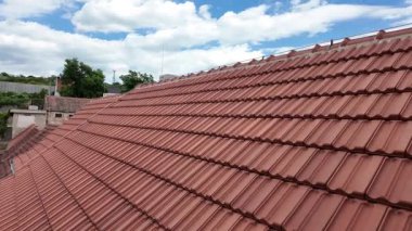 Tarihi bir evin yeni inşa edilen çatısının panoramik görüntüsü. Çatı kiremitleri ve açık mavi gökyüzü ile kaplı yeni bir çatı. Tarih ve ev yenileme kavramı.