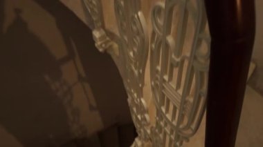 Tarihi bir evde tarihi sarmal merdivenlerden tırmanıyor. Metal işlemeli demir parmaklıklı spiral merdivenler. Tarih, mimari ve kültür mirası kavramı.