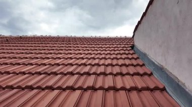 Yeni inşa edilen binanın panoramik manzarası ve tarihi bir evin yurdunun penceresi. Çatı kiremitleri ile kaplı yeni çatı. Ev tarihi ve inşaat kavramı.
