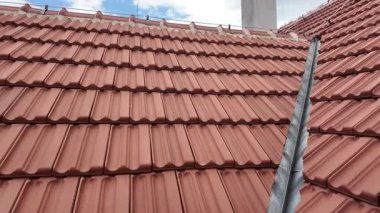 Tarihi bir binanın yeni inşa edilmiş çatısının panoramik görüntüsü. Çatı kiremitleri ve parlak mavi gökyüzü ile kaplı yeni bir çatı. Tarih ve bina yenileme kavramı.