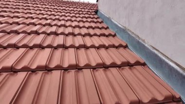 Tarihi bir binanın yeni inşa edilmiş çatısının panoramik görüntüsü. Çatı kiremitleri ve parlak mavi gökyüzü ile kaplı yeni bir çatı. Tarih ve bina yenileme kavramı.