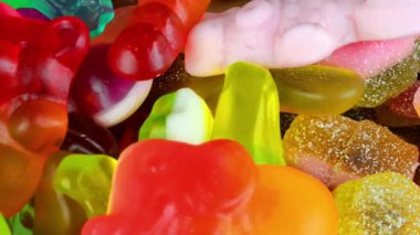 Şekerleme geçmişi. Değişken bir arka planda çok renkli jelibon. Makro çekim, üst görüş. Şeker ve şekerleme kavramı
