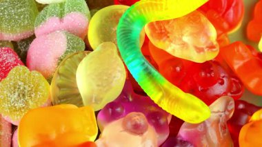 Dönüş geçmişinde jelatin şekerler. Lezzetli jöle şeklinde. Meyve aromalı jöle şekeri kavramı. Üst manzara, makro çekim. Şekerci kavramı, şekerci