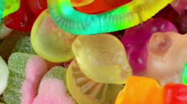 Şekerleme geçmişi. Değişken bir arka planda çok renkli jelibon. Makro çekim, üst görüş, bulanık görüntü. Şeker ve şekerleme kavramı