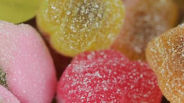 Şekerleme geçmişi. Değişken bir arka planda çok renkli jelibon. Makro çekim, üst görüş. Şeker ve şekerleme kavramı