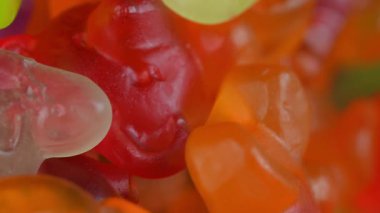 Jelatin tatlılar. Dönen bir yüzeyde jöle şekerlemeleri. Makro atış. Çocukluk, şekerleme ve şeker konsepti