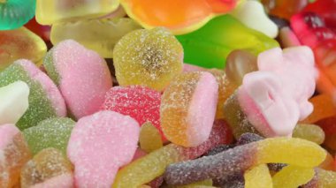 Jelatin tatlılar. Dönen bir yüzeyde jöle şekerlemeleri. Sakızlı meyve tatlısı. Makro atış. Çocukluk kavramı, şeker ve şekerleme