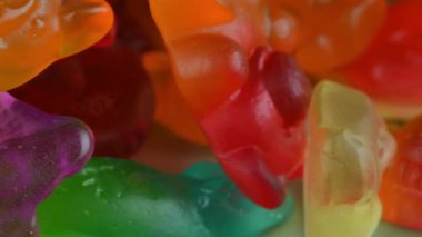 Jelatin tatlılar. Dönen bir yüzeyde jöle şekerlemeleri. Sakızlı meyve tatlısı. Makro atış. Çocukluk kavramı, şeker ve şekerleme