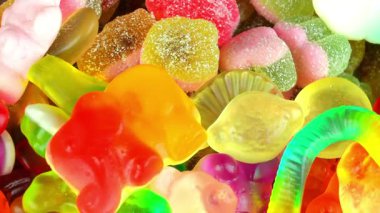 Şekerleme geçmişi. Değişken bir arka planda çok renkli jelibon. Makro çekim, üst görüş. Şeker ve şekerleme kavramı