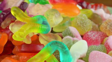 Jelatin tatlılar. Dönen bir yüzeyde jöle şekerlemeleri. Makro atış. Çocukluk, şekerleme ve şeker konsepti