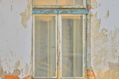 Eski bir pencere ve çizik bir cephe. Eski bir evin penceresi olan tozlu bir cephe. Bina onarım ve onarım kavramı