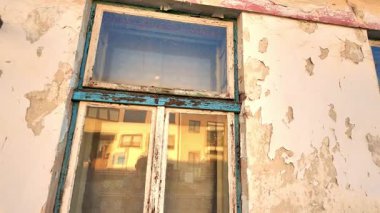 Eski bir evin yıpranmış görüntüsü. Evin eski cephesini, pencerelerini ve kapılarını görüyorum. Emlak acenteleri kavramı, inşaat sektöründe yeniden yapılanma. Yavaş çekim