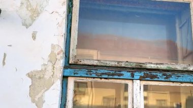 Eski bir evin yıpranmış görüntüsü. Evin eski cephesini, pencerelerini ve kapılarını görüyorum. Emlak acenteleri kavramı, inşaat sektöründe yeniden yapılanma.