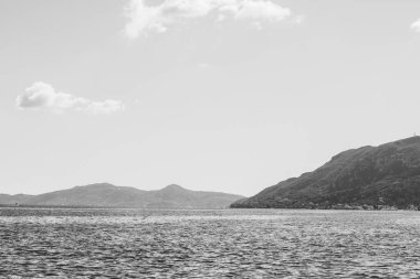 Korfu, Yunanistan. Suyun güzel manzarası, kıyıda kocaman dağlar, mavi gökyüzünün altında..