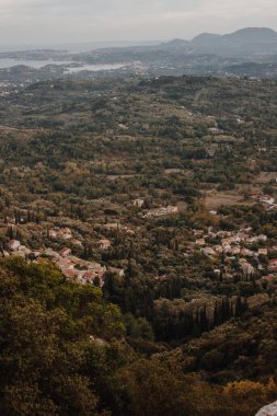 Korfu, Yunanistan. Yeşil ağaçların arasına yerleşmiş şehir evlerinin manzarası.