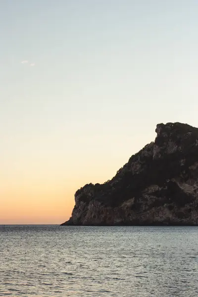 stock image Corfu, Greece. Beautiful landscape with a huge rock in the water at sunset.