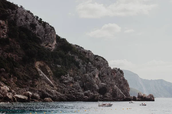 コルフ ギリシャ2022 ボートが動く青い水によって巨大な砂の岩の崖 — ストック写真
