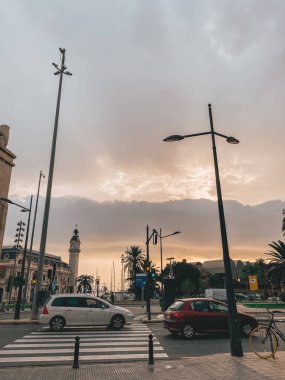 17.10.2022. Valencia, İspanya. Gün batımında şehir manzarası trafik ışıkları ve yolda giden arabalar için bir saatle.