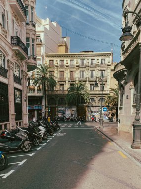 17.10.2022. Valencia, İspanya. Şehir manzarası, yol kenarına scooterların park edildiği metal balkonlu binalar..