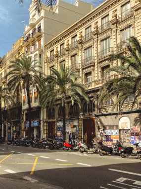 17.10.2022. Valencia, İspanya. Şehir manzarası, yol kenarına scooterların park edildiği metal balkonlu binalar..