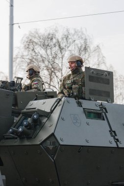 18.11.2022 Riga, Letonya. Ulusal tatillerde askeri geçit töreni. Askerler tanklarla gelip yol kenarındaki insanlara el sallıyor..