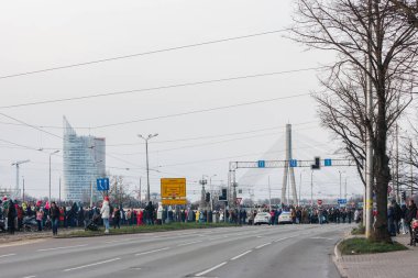 18.11.2022 Riga, Letonya. Letonya ulusal bayramında askeri geçit töreni. Bir grup insan sokakta durup askeri geçit törenini izliyor..