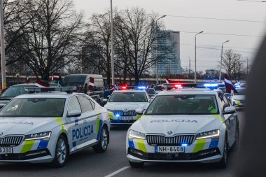 18.11.2022 Riga, Letonya. Askeri geçit töreni. Mavi fenerli hafif polis araçları..