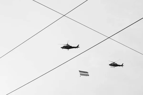 2022年11月18日 拉脱维亚里加 军队直升机在灰色的秋天天空中飞行的阅兵式 一架直升机悬挂拉脱维亚国旗 — 图库照片