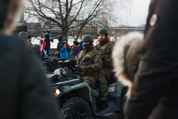 stock image 18.11.2022 Riga, Latvia. Military parade on national holidays. Soldiers ride a green quad bike